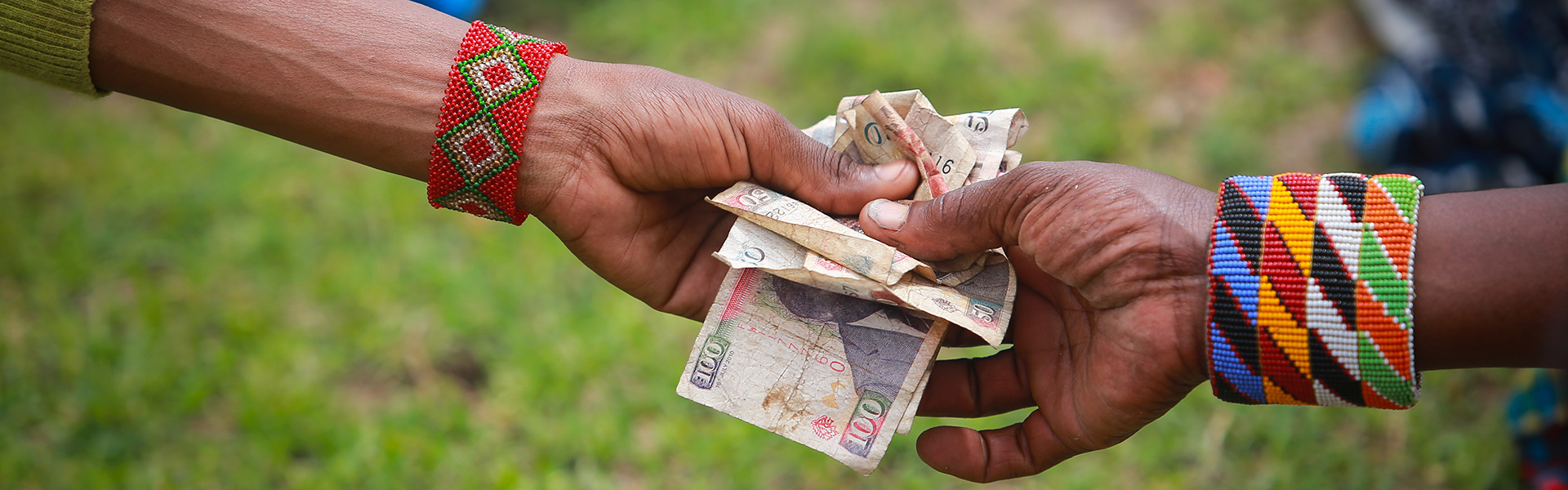Two hands exchanging money.